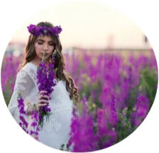 Schwangere Frau mit Blumenkranz in einem violetten Blumenfeld