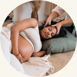 Schwangere Frau bei einer sanften Kopfmassage in einer gemütlichen Boho-Umgebung